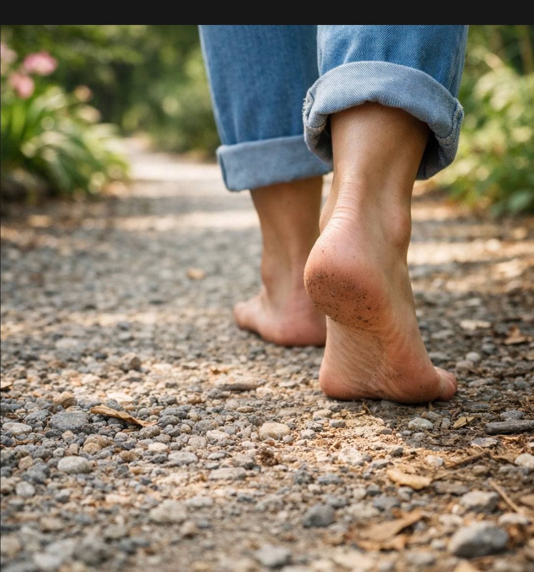 Bare feet walking a gravel path — moving forward through grief